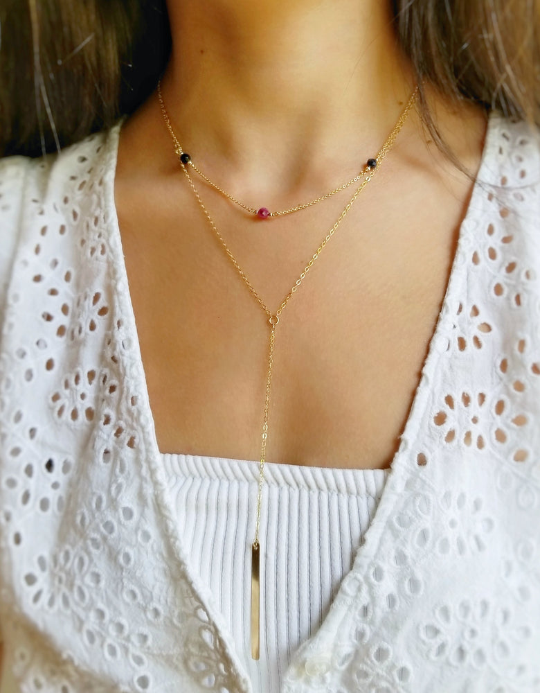 model wearing three stoned birthstone necklace layered with the gold drop bar necklace