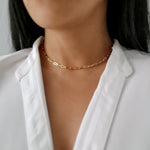 customer wearing gold linked necklace layered with the gold tag necklace