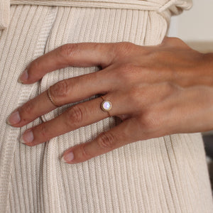 Model wearing a gold round opal ring